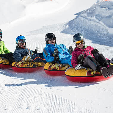 Four people snowtubing in Zillertal