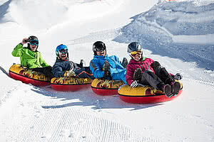 Four people snowtubing in Zillertal