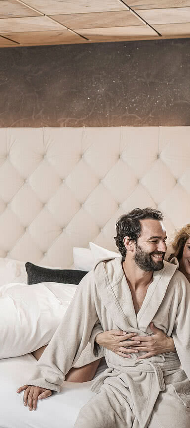 Couple sitting on a comfortable bed in STOCK resort