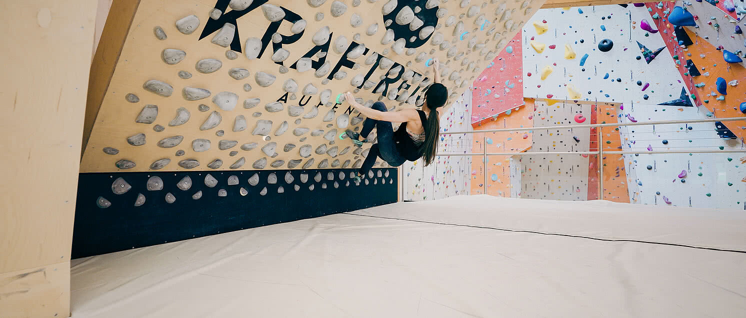 Frau bouldert in der Kletterhalle Aschau