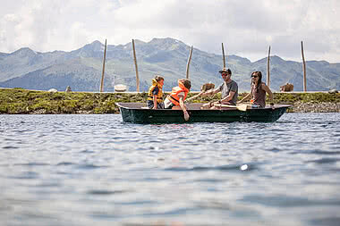 Family in a row boat on Fichtensee during an family adventure holiday in Austria