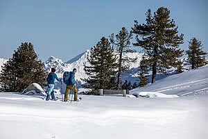 Couple snow-shoe hiking in Tyrol