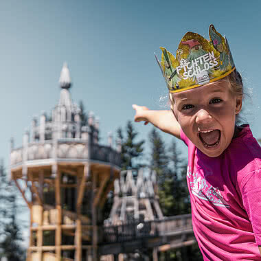 Kind zeigt auf das Fichtenschloss im Abenteuer Familienurlaub