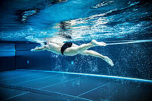 Mann schwimmt im Pool vom 5 Sterne Wellnesshotel Österreich