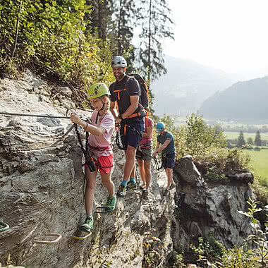 Family on a via ferrata route in Talbach during a climbing holiday in Austria