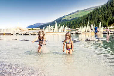 Children playing in Fichtensee during an family adventure holiday in Austria