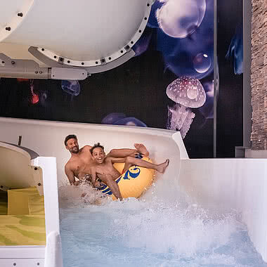 Father and son sliding in Family Hotel STOCK resort Austria