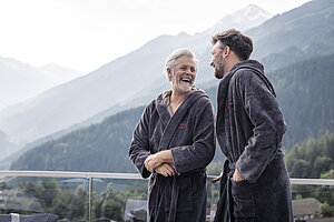 Zwei Männer im Bademantel auf der Terrasse – 5 sterne wellnesshotel österreich – STOCK resort Zillertal 