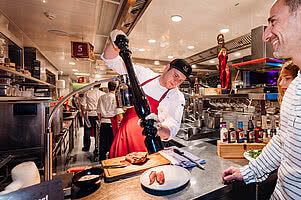 Chef seasoning a meal at Kitchenparty in gourmet hotel STOCK resort in Austria