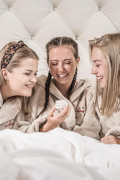 Three women in bathing robes in the 5 star wellness hotel STOCK resort Austria